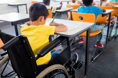 educação especial inclusiva - criança de cadeira de rodas na aula